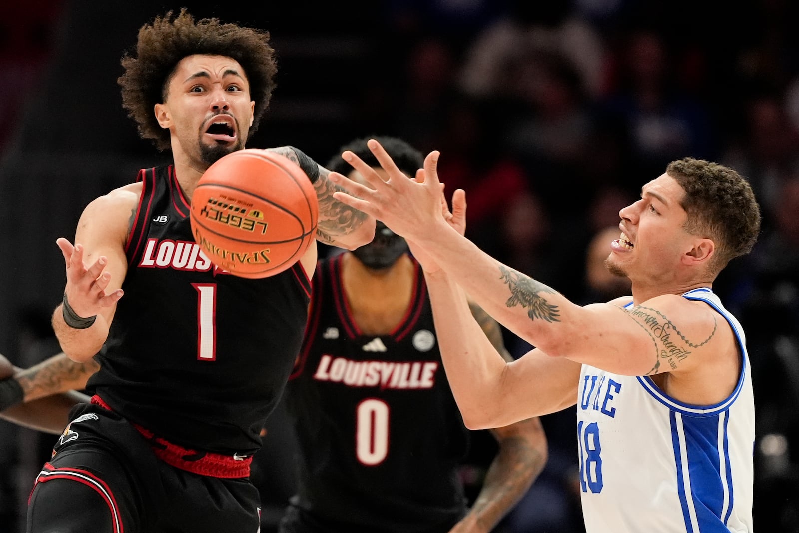 Louisville guard J'Vonne Hadley, left, steals the ball away from Duke forward Mason Gillis during the first half of an NCAA college basketball game in the championship of the Atlantic Coast Conference tournament, Saturday, March 15, 2025, in Charlotte, N.C. (AP Photo/Chris Carlson)