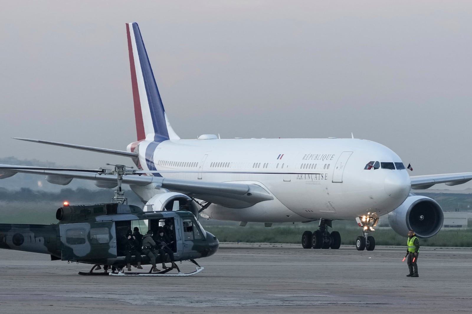 Lebanese soldiers in a helicopter stand guard as French President Emmanuel Macron's plane taxis upon his arrival at Beirut's Rafic Hariri International Airport in Beirut, Lebanon, Friday, Jan. 17, 2025. (AP Photo/Hassan Ammar)