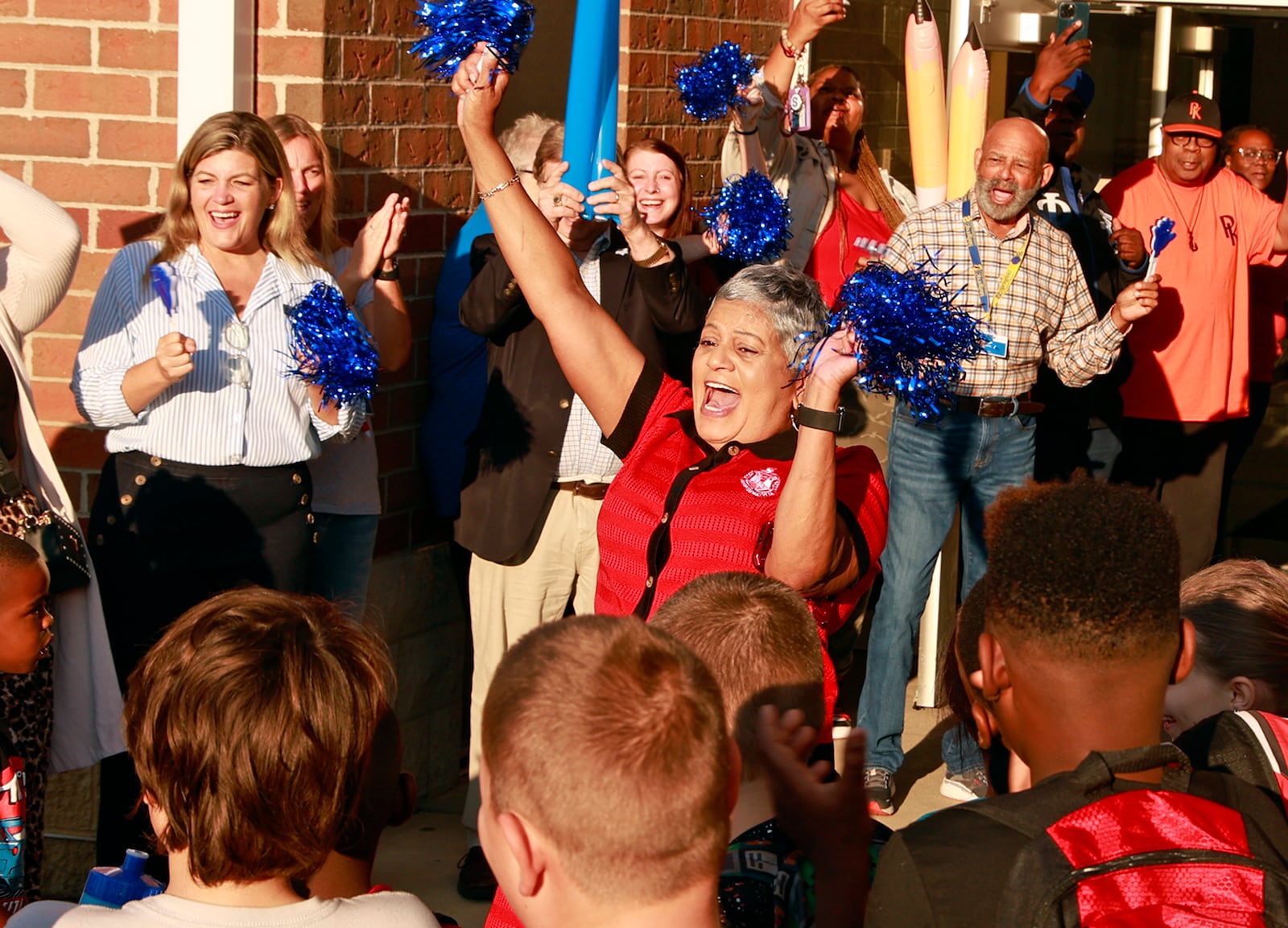 Fulton Elementary School Principal Deborah Howard celebrates with members of the community during a "Fulton First Day Clap-in" for the students as they arrive at school Wednesday, August 14, 2024. BILL LACKEY/STAFF