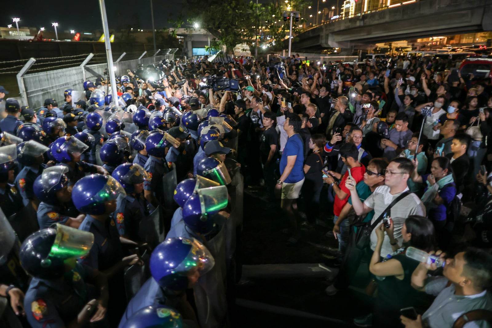 Supporters of former President Rodrigo Duterte rush to the fence of the Villamor Air Base in Manila, Philippines, Wednesday March 11, 2025, upon learning that the plane taking the ex-president to The Hague has left the airport. (AP Photo/Gerard Carreon)