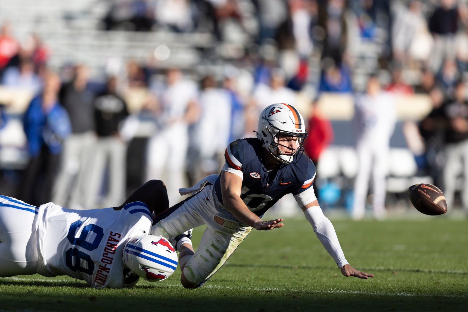 Virginia quarterback Anthony Colandrea (10) is sacked by SMU defensive tackle Mike Yoan Sandjo-Njiki (98) during the second half of an NCAA college football game, Saturday, Nov. 23, 2024, in Charlottesville, Va. (AP Photo/Mike Kropf)