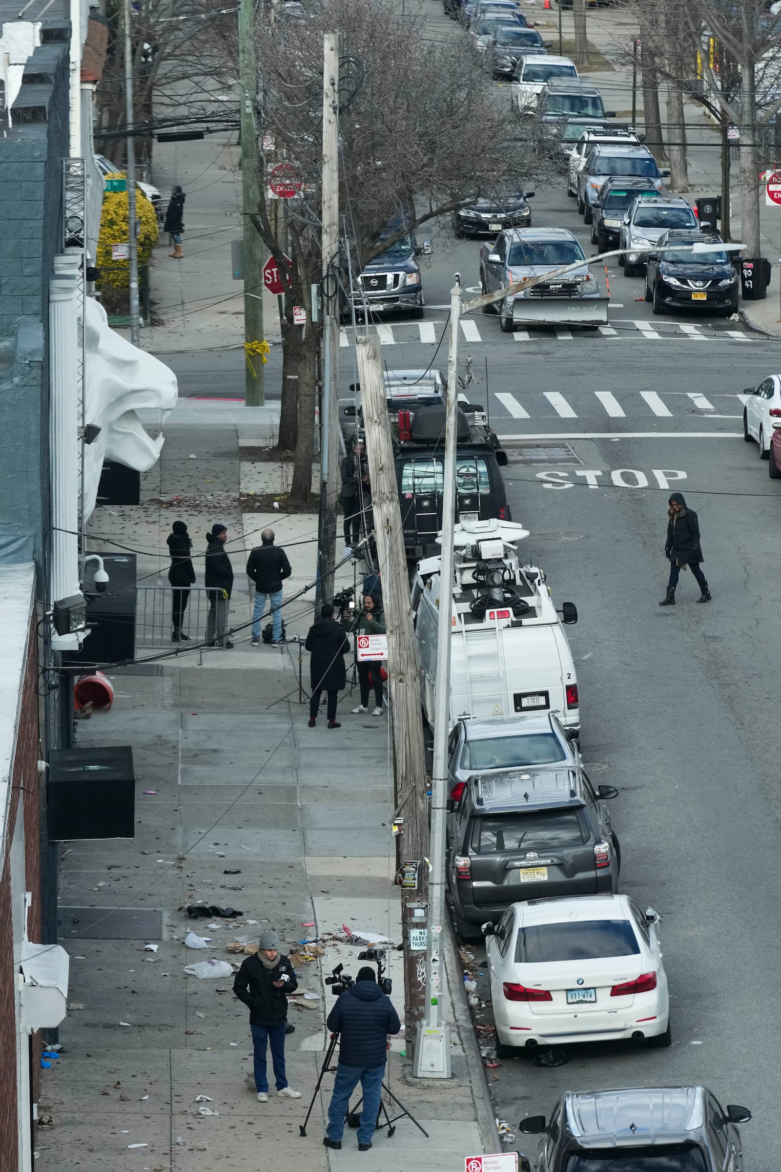 Members of the media work in front of the nightclub Amazura, left, in the Queens borough of New York, Thursday, Jan. 2, 2025. (AP Photo/Seth Wenig)