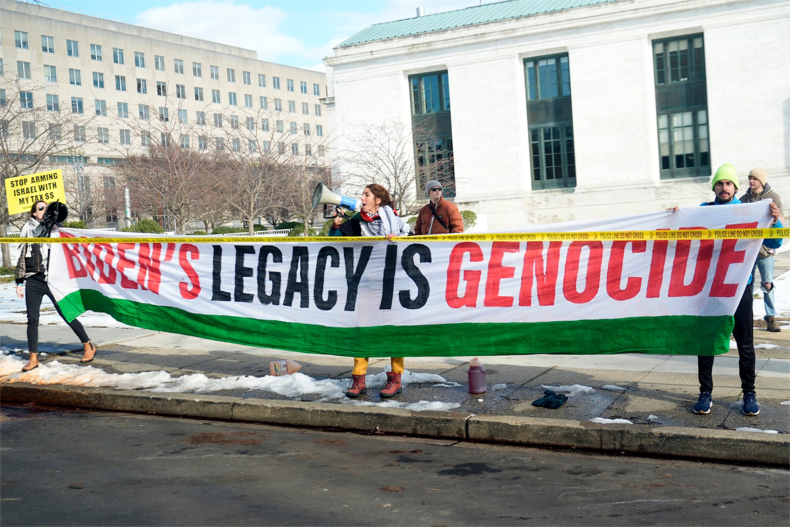 Protesters line the street as President Joe Biden's motorcade passes on its way to the State Department for Biden to speak about foreign policy in Washington, Monday, Jan. 13, 2025. (AP Photo/Susan Walsh)