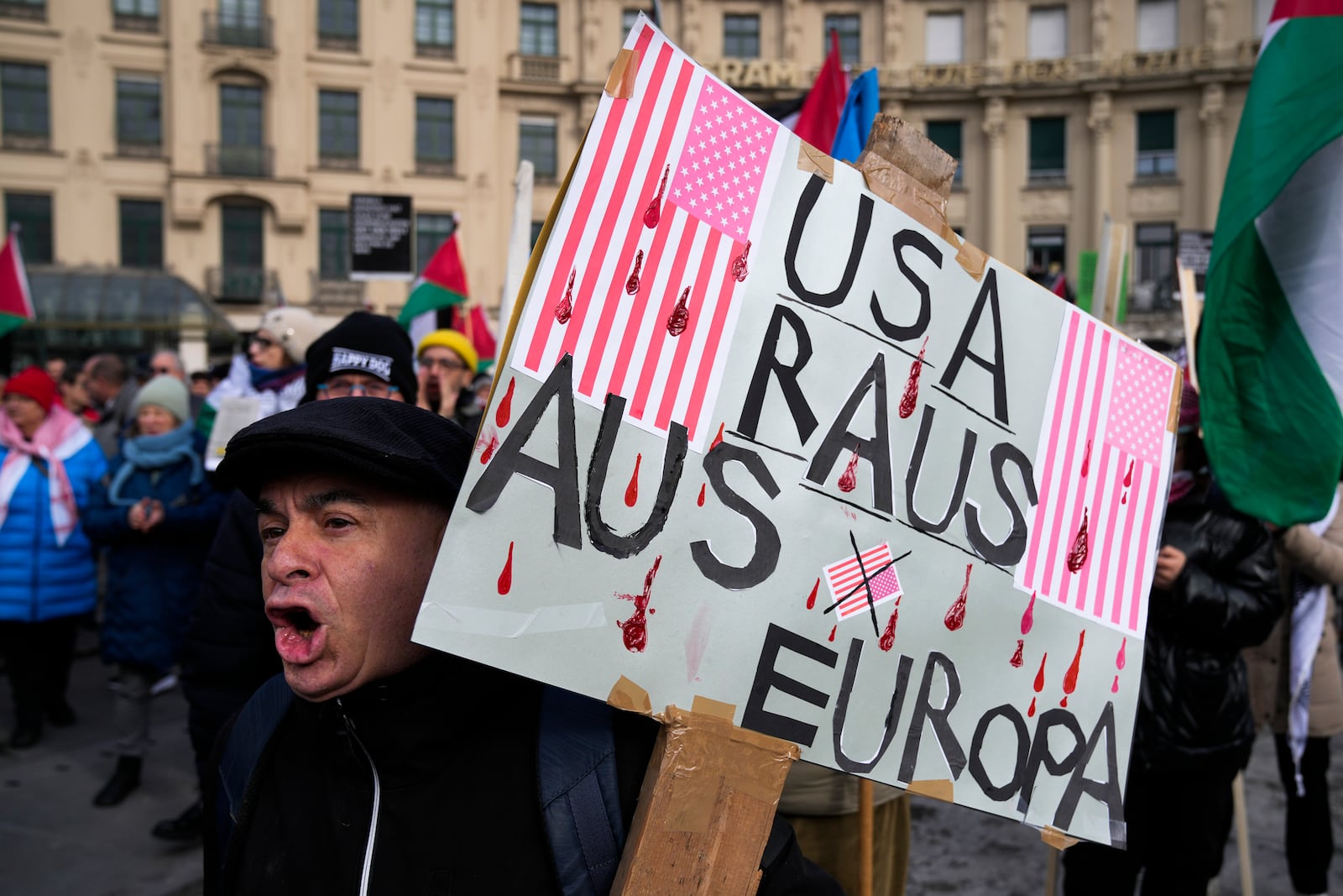 A man holds a poster reading: "USA: Out of Europe: during a protest against the Munich Security Conference in Munich, Saturday, Feb. 15, 2025. (AP Photo/Ebrahim Noroozi)