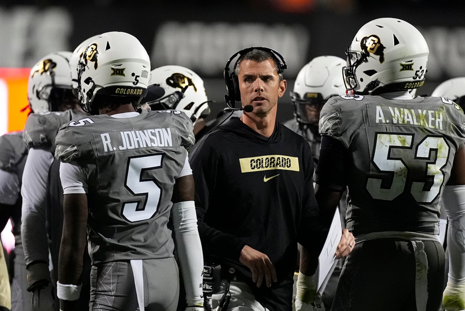 Colorado defensive coordinator Robert Livingston, center, confers with safety RJ Johnson, left, and defensive end Arden Walker in the second half of an NCAA college football game against Cincinnati Saturday, Oct. 26, 2024, in Boulder, Colo. AP Photo/David Zalubowski)