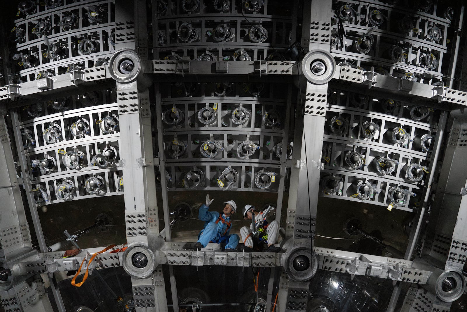 Workers labor on the underside of the cosmic detector located 2297 feet (700 meters) underground at the Jiangmen Underground Neutrino Observatory in Kaiping, southern China's Guangdong province on Friday, Oct. 11, 2024. (AP Photo/Ng Han Guan)