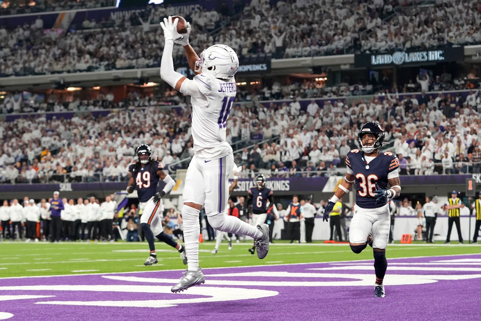 Minnesota Vikings wide receiver Justin Jefferson (18) catches a 7-yard touchdown pass in front of Chicago Bears safety Jonathan Owens (36) during the first half of an NFL football game, Monday, Dec. 16, 2024, in Minneapolis. (AP Photo/Abbie Parr)