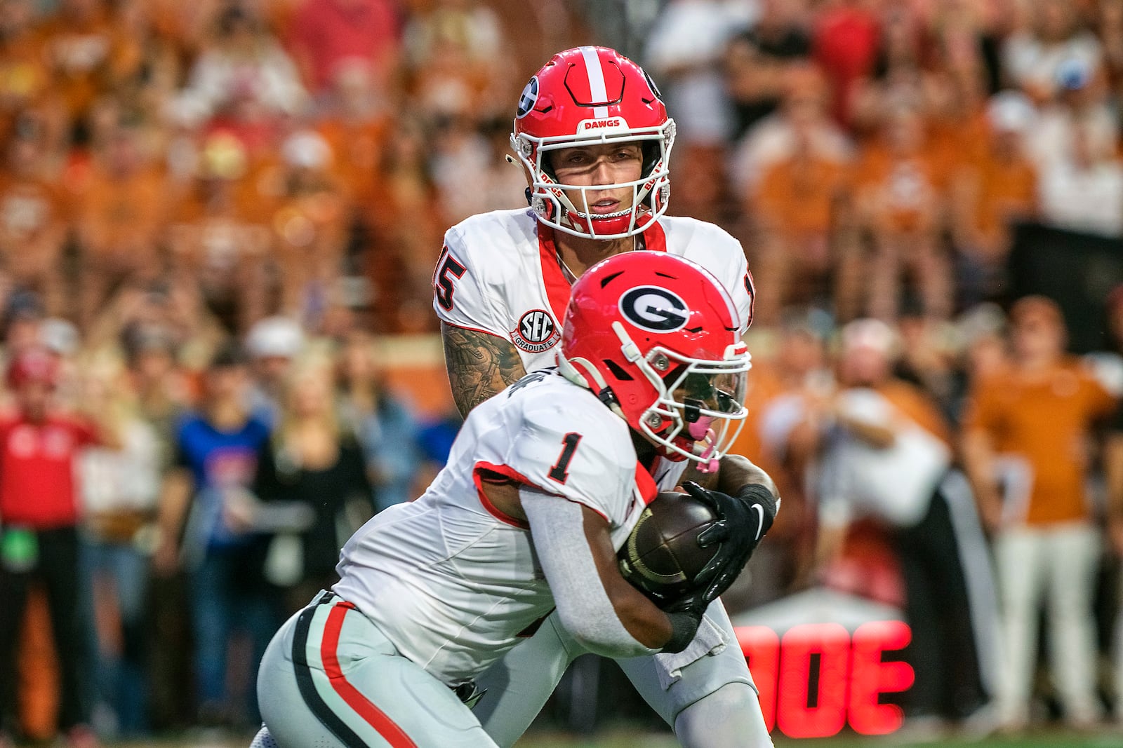 Georgia quarterback Carson Beck (15) hands the ball off to Georgia running back Trevor Etienne (1) during the first half of an NCAA college football game against Texas in Austin, Texas, Saturday, Oct. 19, 2024. (AP Photo/Rodolfo Gonzalez)