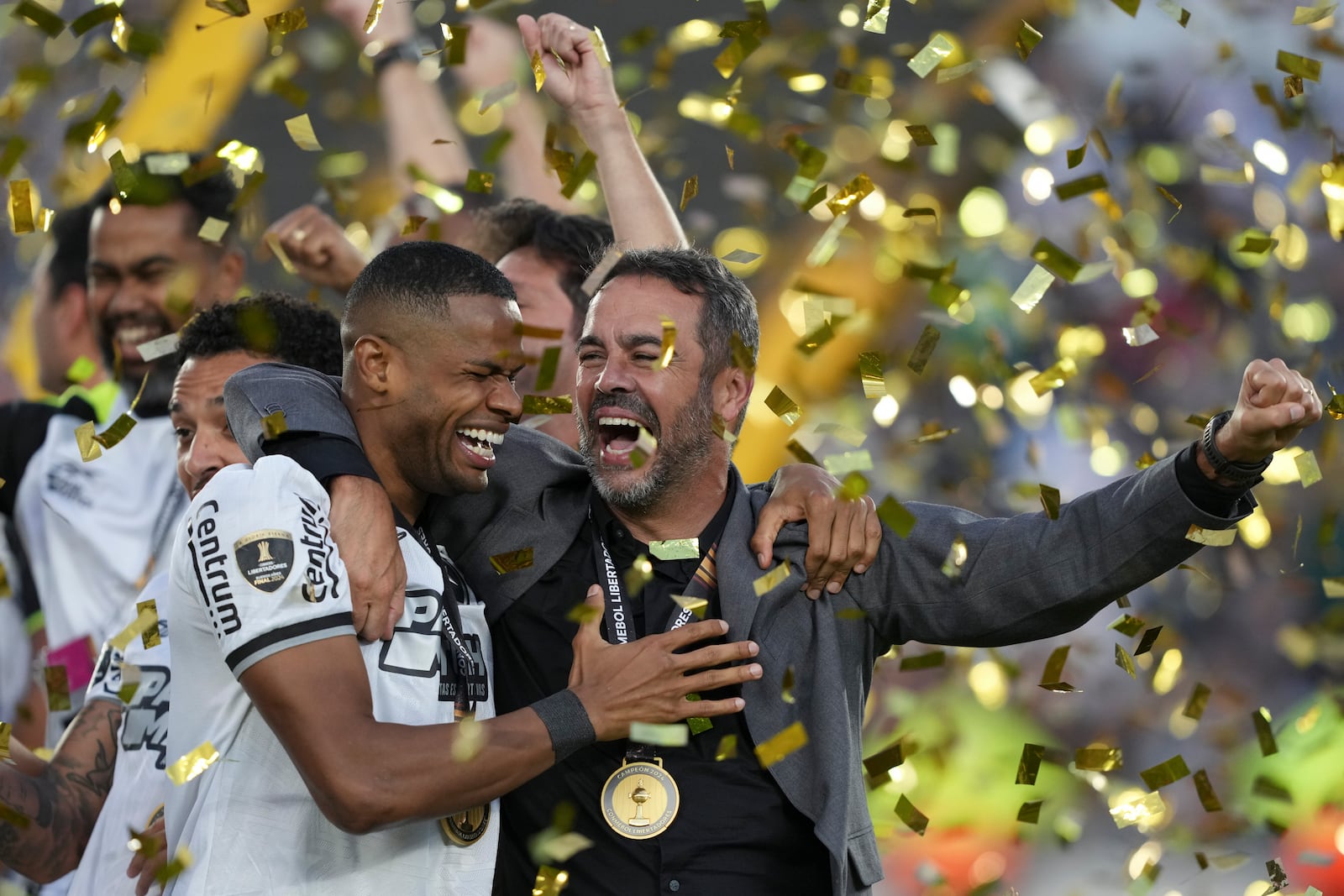 Coach Artur Jorge of Brazil's Botafogo, right, celebrates with his players after winning the Copa Libertadores final soccer match against Brazil's Atletico Mineiro at Monumental stadium in Buenos Aires, Argentina, Saturday, Nov. 30, 2024. (AP Photo/Gustavo Garello)