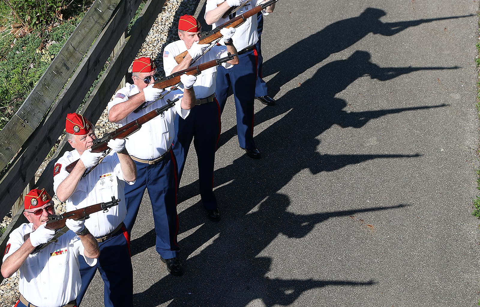 A 21 gun salute is held by the Marine Corp. League as a wreath is tossed into Buck Creek at the beginning of the Springfield Memorial Day Parade Monday, May 30, 2022. BILL LACKEY/STAFF