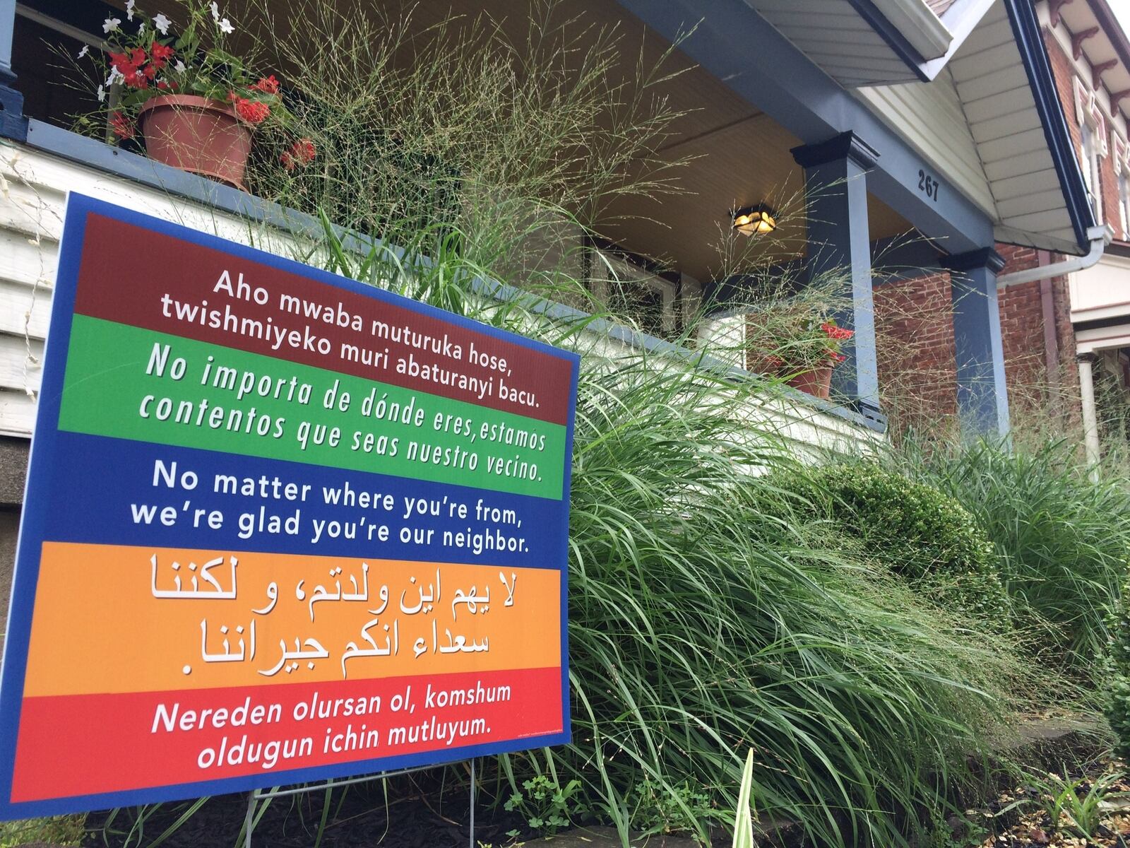 A sign outside a home in the South Park neighborhood sends a welcoming message to people who speak other languages. CORNELIUS FROLIK / STAFF