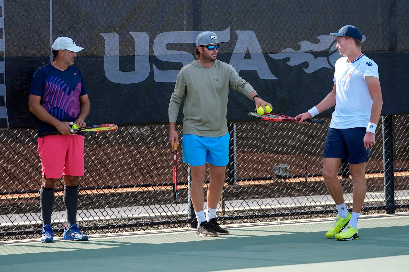 Tennis coaches Eric Nunez, left, and Rhyne Williams, center, work with Jenson Brooksby, right, at the USTA national campus Tuesday, Dec. 10, 2024, in Orlando, Fla. (AP Photo/John Raoux)