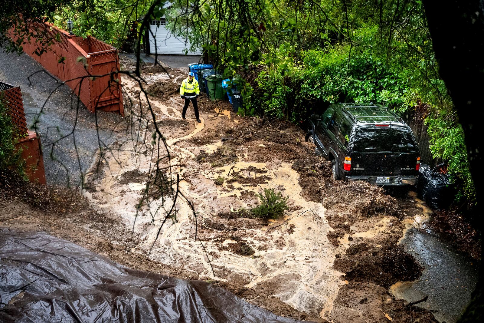 Permit Sonoma Director Tennis Wick crosses a mudslide to inspect a home as heavy rains fall near Healdsburg in unincorporated Sonoma County, Calif., on Friday, Nov. 22, 2024. (AP Photo/Noah Berger)