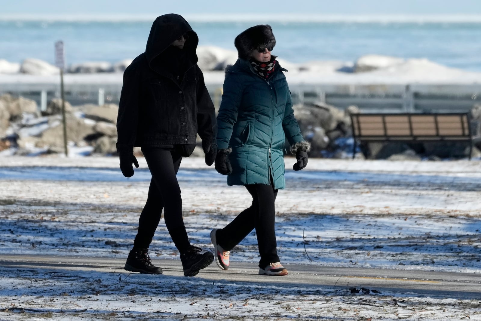 Pedestrians bundle up as they take a walk during cold weather in Evanston, Ill., Wednesday, Jan. 8, 2025. (AP Photo/Nam Y. Huh)