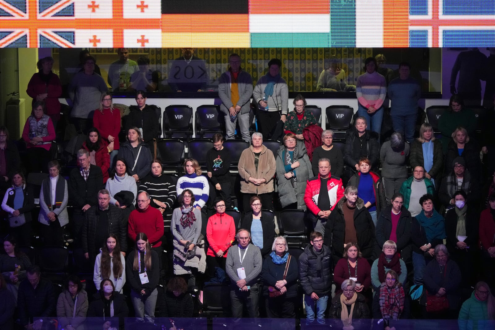 Spectators observe a moment of silence for the DC aircraft crash victims, Thursday, Jan. 30, 2025, at the ISU European Figure Skating Championships in Tallinn, Estonia. (AP Photo/Sergei Grits)