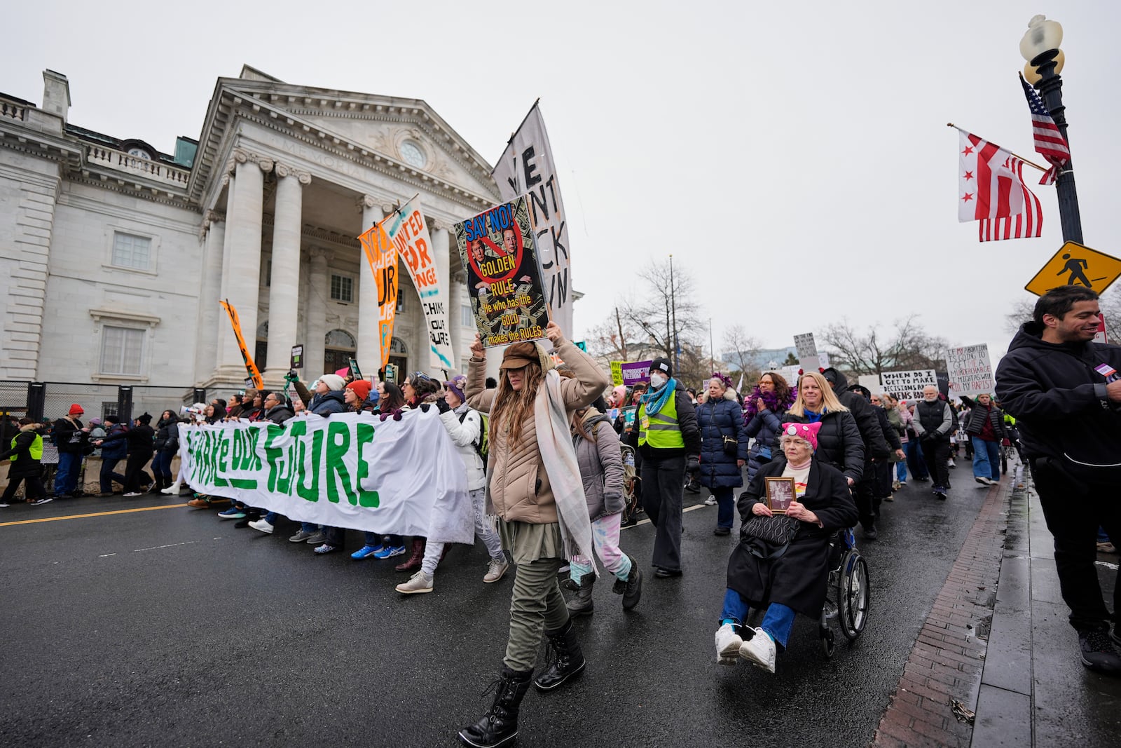 People march past the Daughters of the American Revolution National Headquarters building during the People's March, Saturday, Jan. 18, 2025, in Washington. (AP Photo/Mike Stewart)