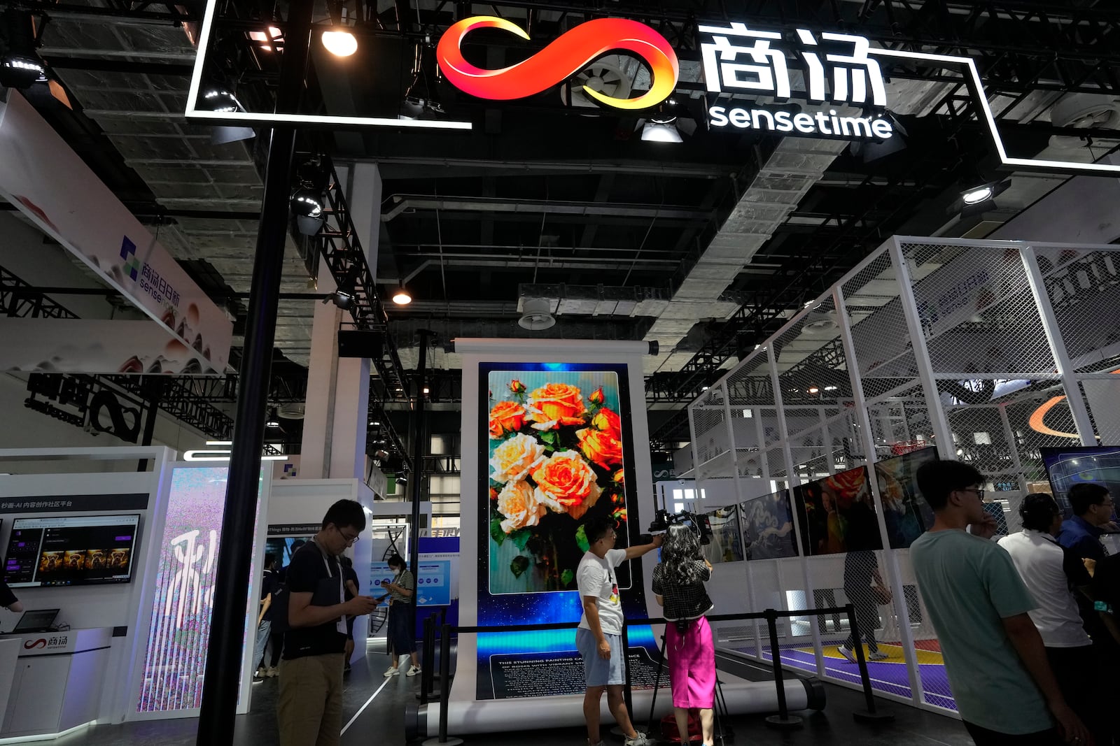 FILE - The booth for Chinese artificial intelligence company Sensetime demonstrates its AI generated images during the World AI Conference in Shanghai, July 5, 2023. (AP Photo/Ng Han Guan, File)