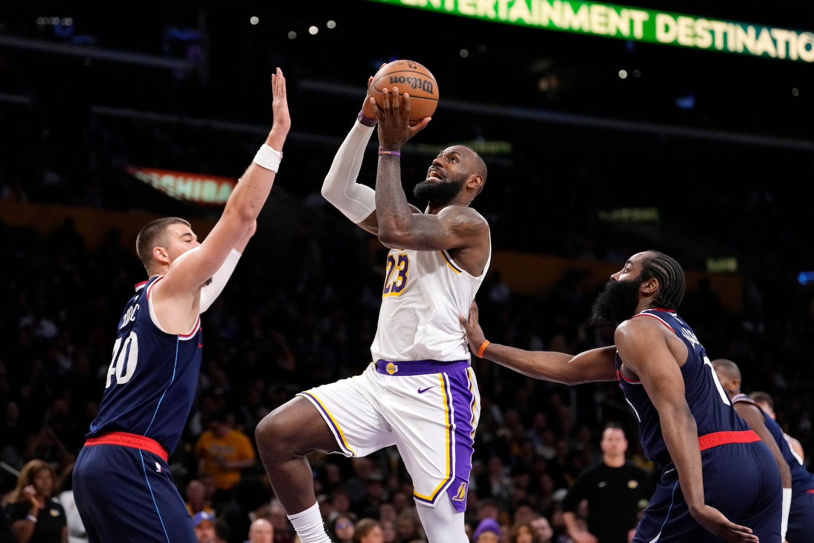 Los Angeles Lakers forward LeBron James, center, shoots as Los Angeles Clippers center Ivica Zubac, left, and guard James Harden defend during the second half of an NBA basketball game Sunday, March 2, 2025, in Los Angeles. (AP Photo/Mark J. Terrill)