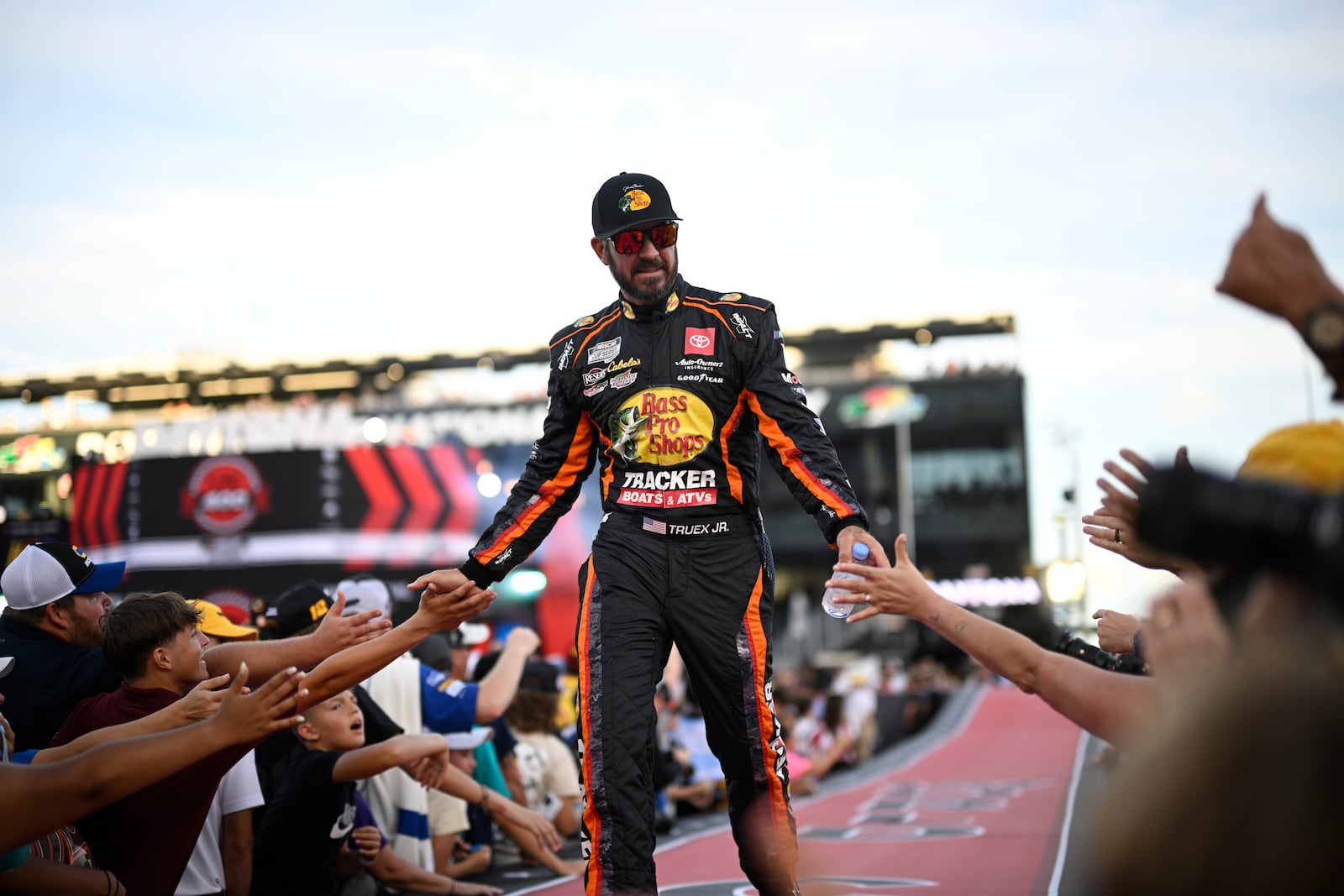 FILE Martin Truex Jr. interacts with spectators while walking down a runway during driver introductions before a NASCAR Cup Series auto race at Daytona International Speedway, Aug. 24, 2024, in Daytona Beach, Fla. (AP Photo/Phelan M. Ebenhack, file)