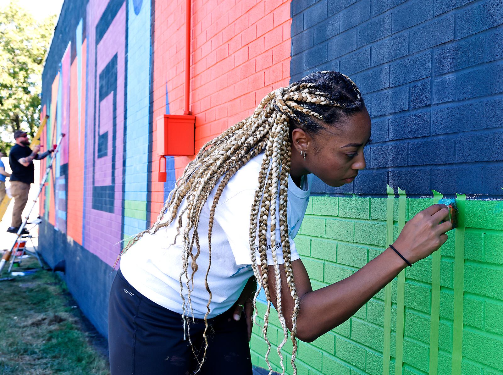 Artists Janel Young works on the new mural on the north side of The Career Connect Ed and The Dome building Monday, Sept. 9, 2024. BILL LACKEY/STAFF