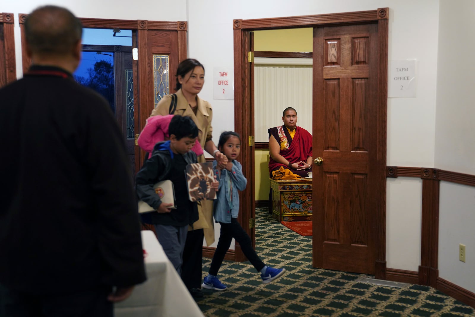 U.S.-born Buddhist lama, Jalue Dorje, right, waits in a private room before making an entrance at his 18th birthday and enthronement ceremony that hundreds attended in Isanti, Minn., on Saturday, Nov. 9, 2024. (AP Photo/Jessie Wardarski)