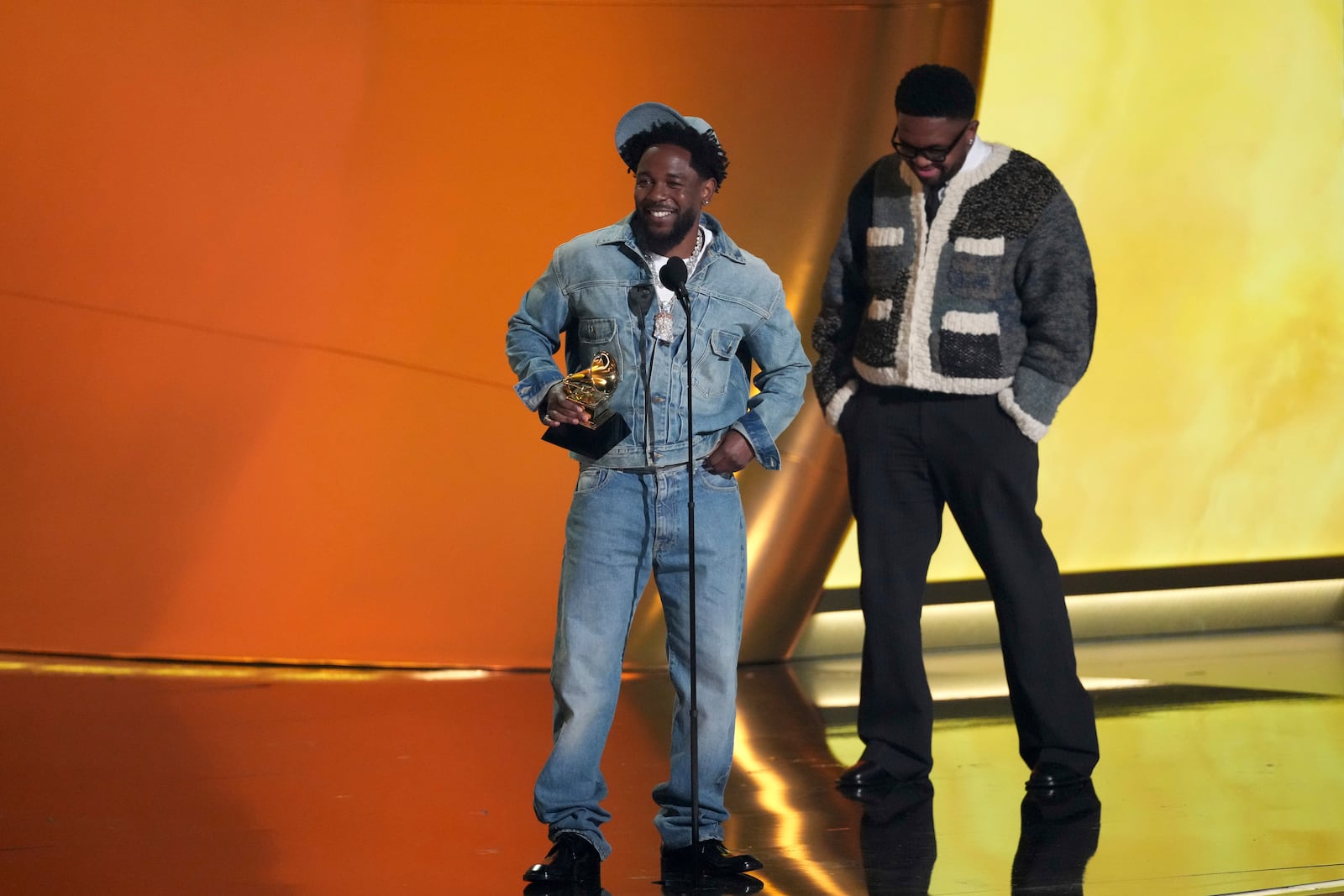 Kendrick Lamar, left, accepts the record of the year award for "Not Like Us during the 67th annual Grammy Awards on Sunday, Feb. 2, 2025, in Los Angeles. Mustard looks on from right. (AP Photo/Chris Pizzello)