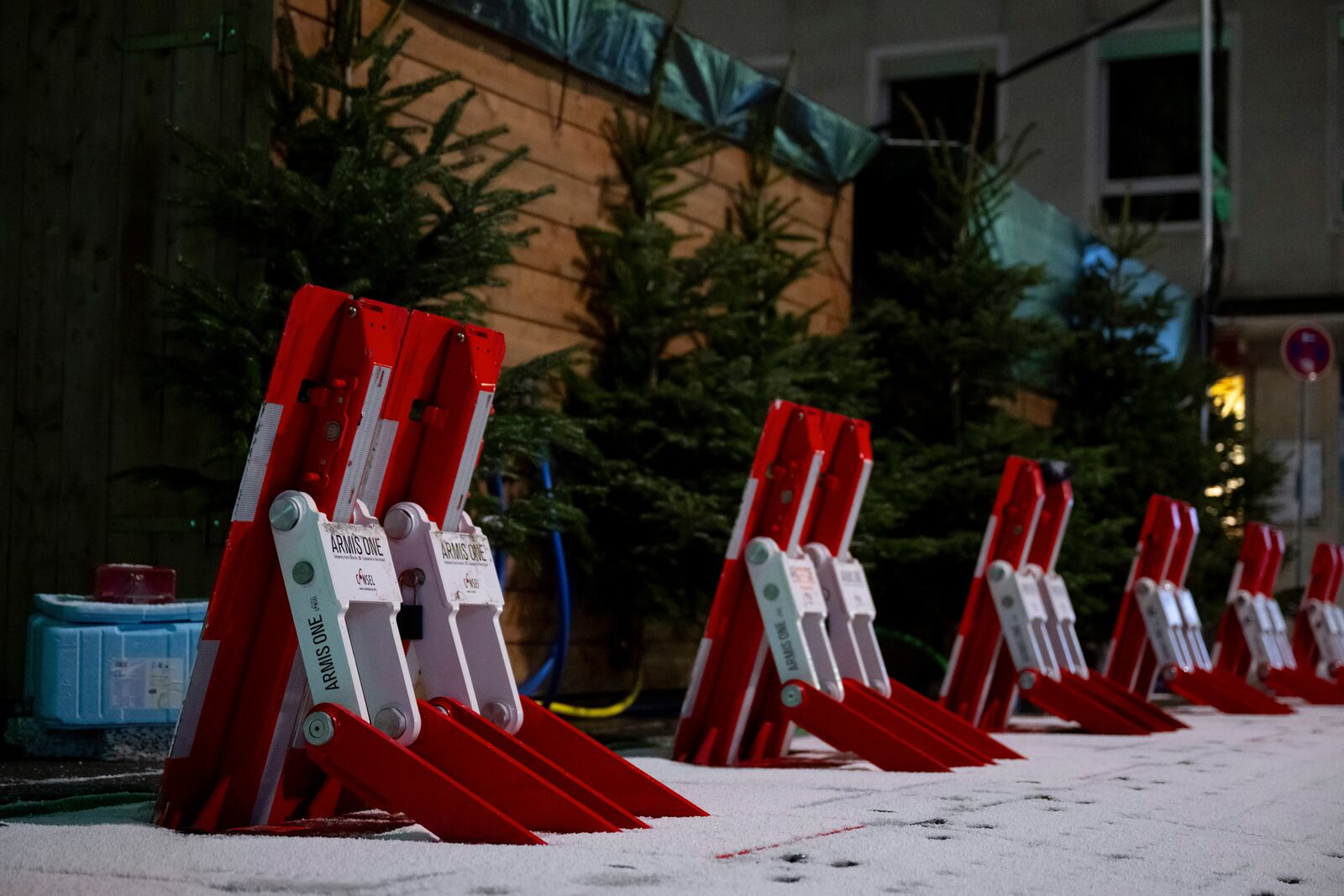 Mobile vehicle barriers can be seen behind the stalls at the Christmas market on Rotkreuzplatz, early Monday, Dec. 23, 2024, in Munich. (Sven Hoppe/dpa via AP)