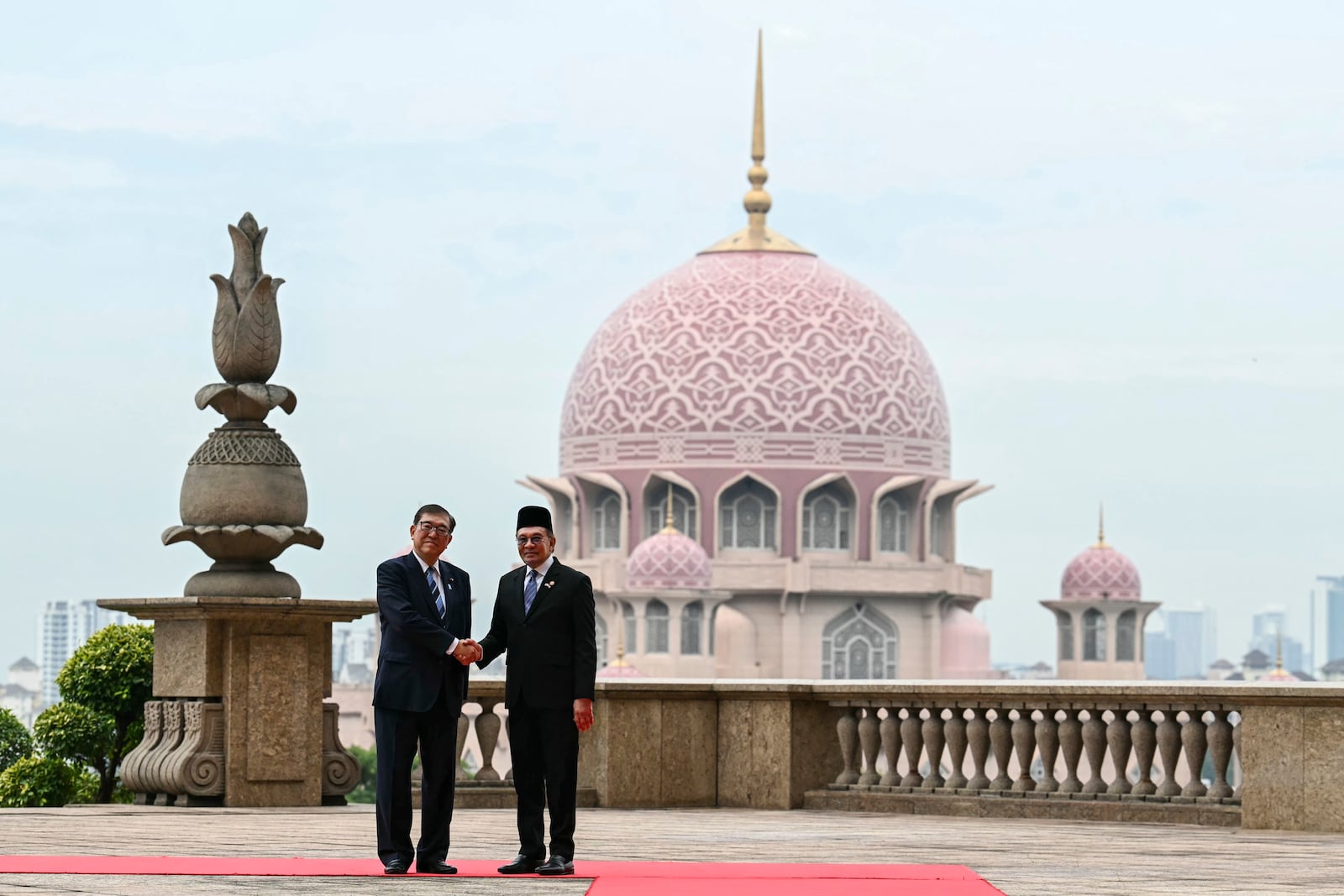 Malaysia's Prime Minister Anwar Ibrahim, right, and Japan's Prime Minister Shigeru Ishiba shake hands before a meeting in Putrajaya, Malaysia, Friday, Jan. 10, 2025. (Mohd Rasfan/Pool Photo via AP)