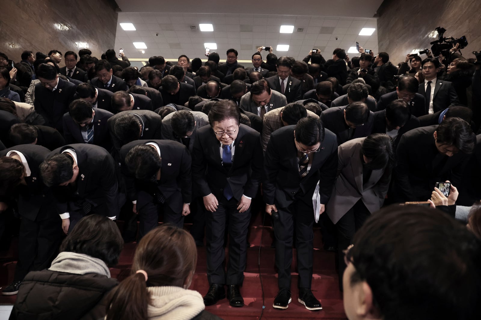 South Korea's main opposition Democratic Party leader Lee Jae-myung, bottom center, and his party members bow at the National Assembly in Seoul, South Korea, after South Korea’s parliament voted to impeach President Yoon Suk Yeol Saturday, Dec. 14, 2024. (Kim Ju-hyung/Yonhap via AP)