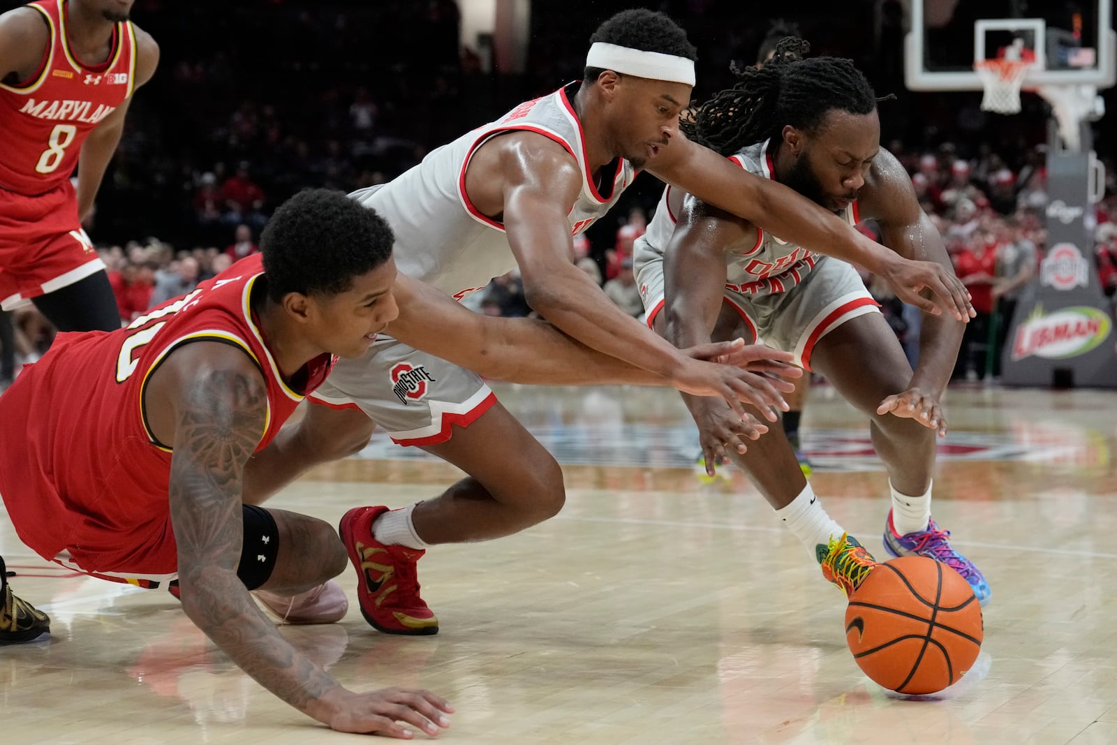 Maryland's Julian Reese, left, reaches for the ball with Ohio State's Micah Parrish, center, and Bruce Thornton, right, in the first half of an NCAA college basketball game Thursday, Feb. 6, 2025, in Columbus, Ohio. (AP Photo/Sue Ogrocki)