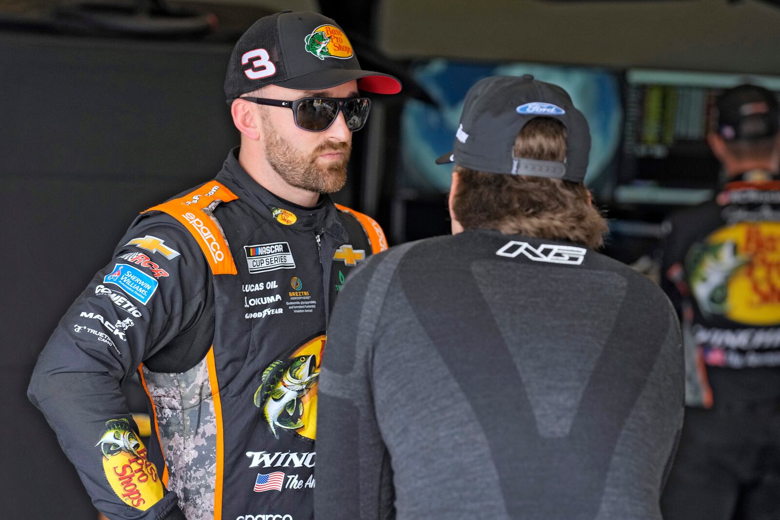 Austin Dillon, left, talks to Noah Gragson in the garage area before a practice for the NASCAR Daytona 500 auto race Wednesday, Feb. 12, 2025, at Daytona International Speedway in Daytona Beach, Fla. (AP Photo/Chris O'Meara)