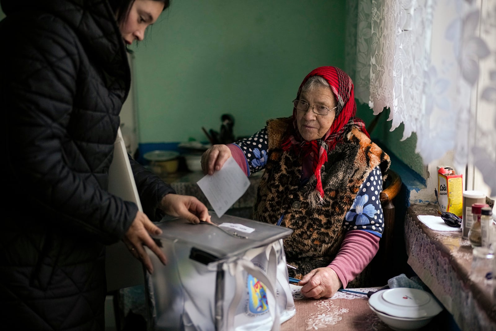 A woman casts her vote in a mobile ballot box during a presidential election runoff, in the village of Ciopleni, Moldova, Sunday, Nov. 3, 2024. (AP Photo/Vadim Ghirda)