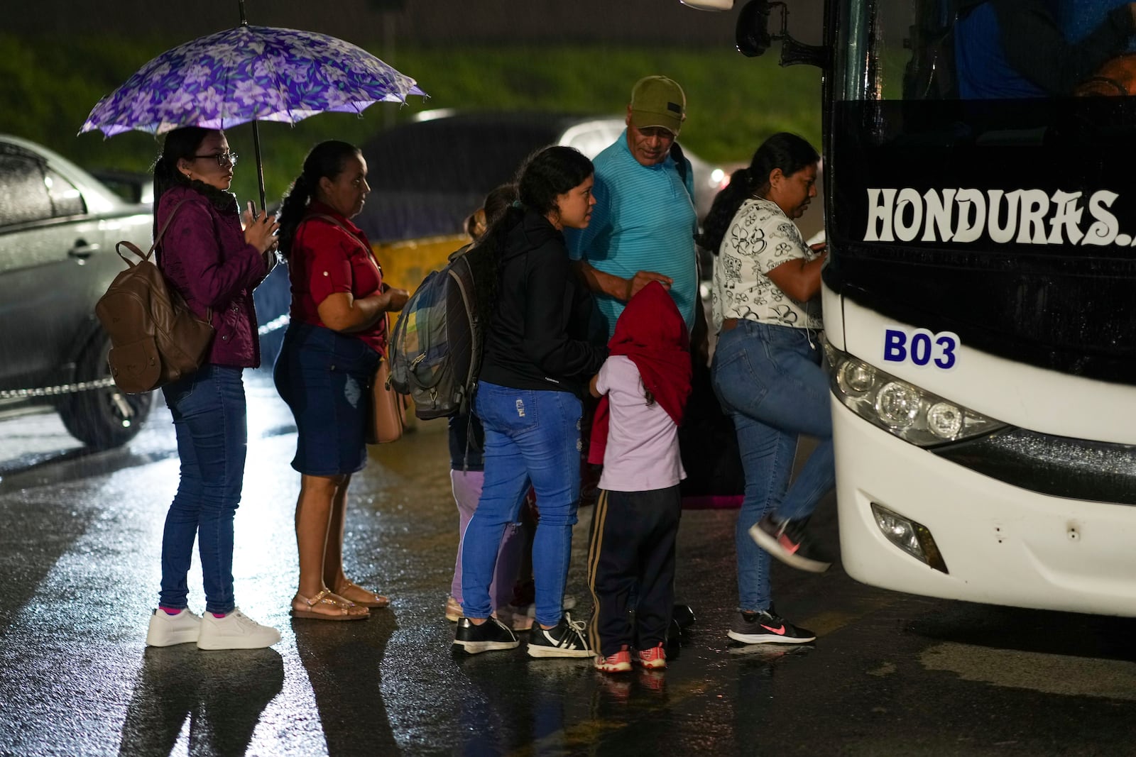 People, mostly Honduran migrants, get on a bus in the hope of reaching the U.S., in San Pedro Sula, Honduras, Tuesday, Dec. 3, 2024. (AP Photo/Moises Castillo)