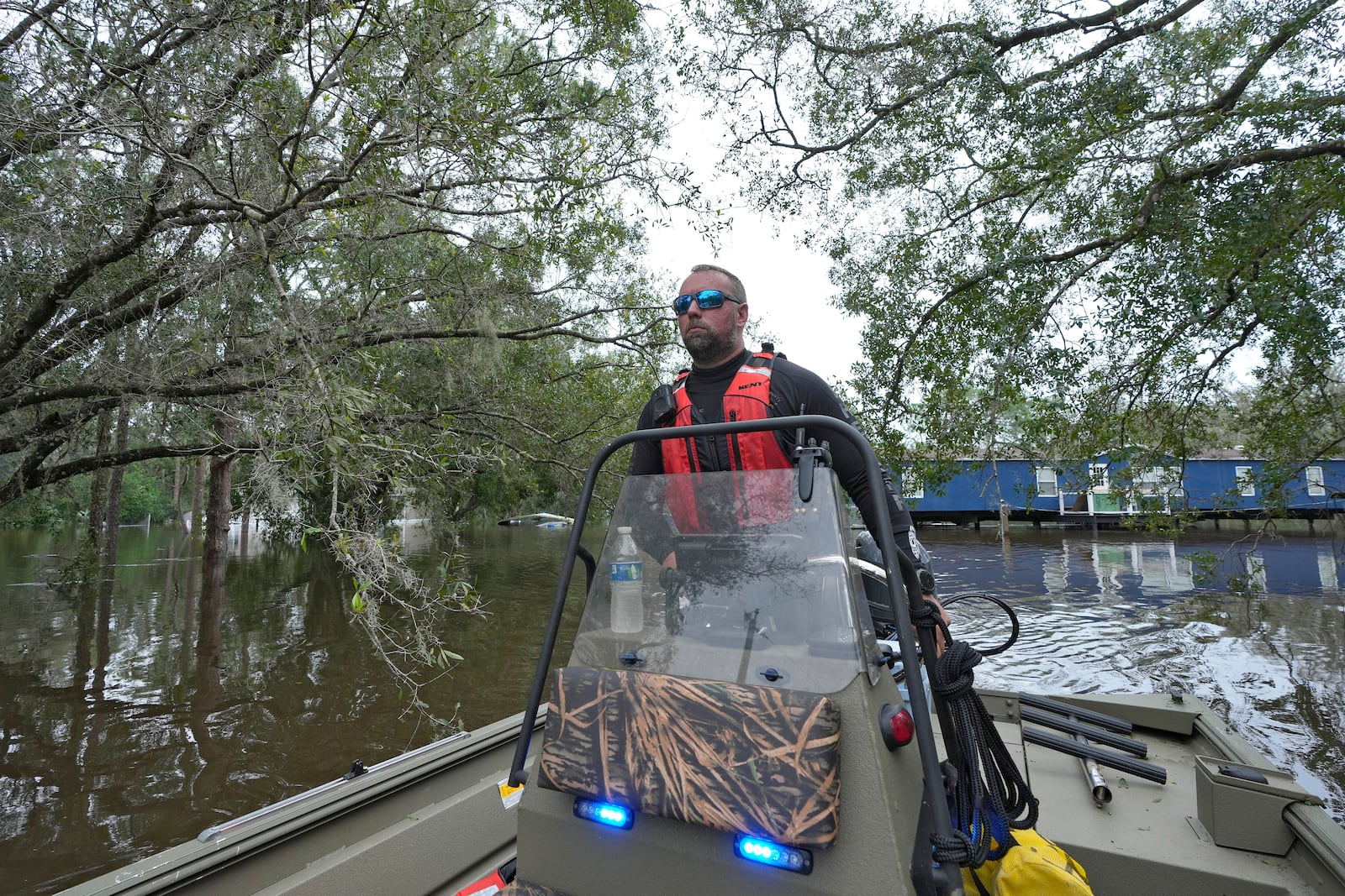 Hillsborough County Master Deputy Robert Unger guides a boat through floodwaters from Hurricane Milton along the Alafia river Friday, Oct. 11, 2024, in Lithia, Fla. (AP Photo/Chris O'Meara)