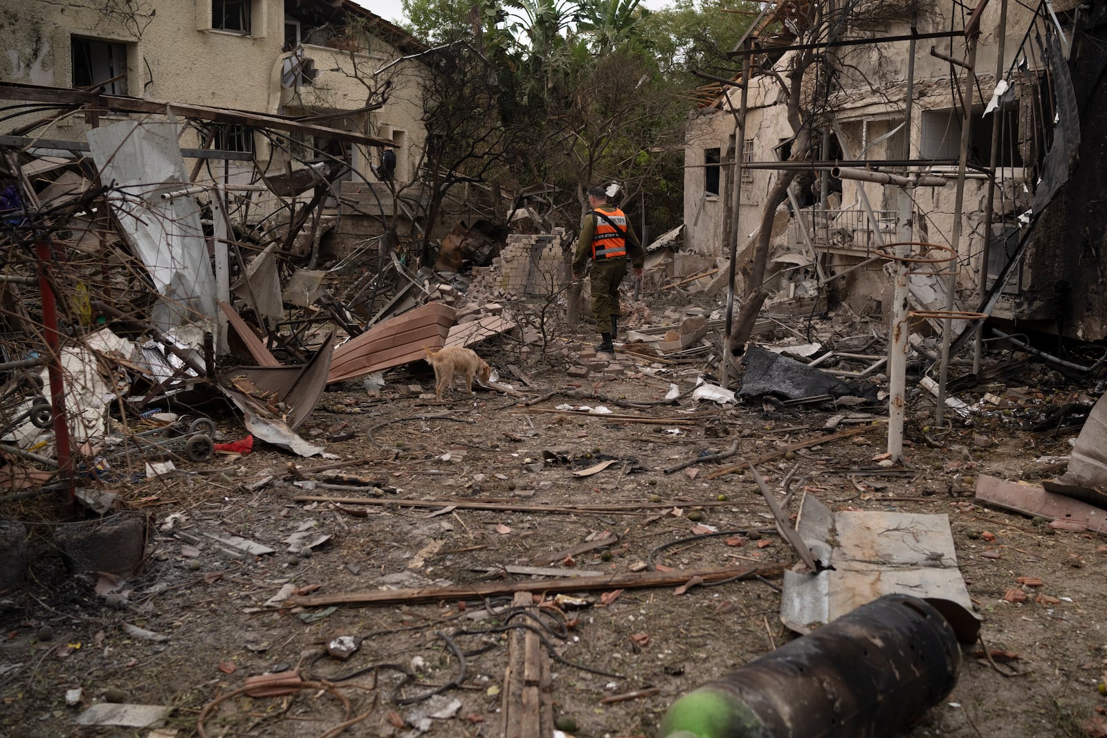 A member of the Israeli forces inspect a site following a rocket fired from Lebanon hit an area in Rinatya, outskirts of Tel Aviv, Israel, Sunday, Nov. 24, 2024. (AP Photo/Leo Correa)