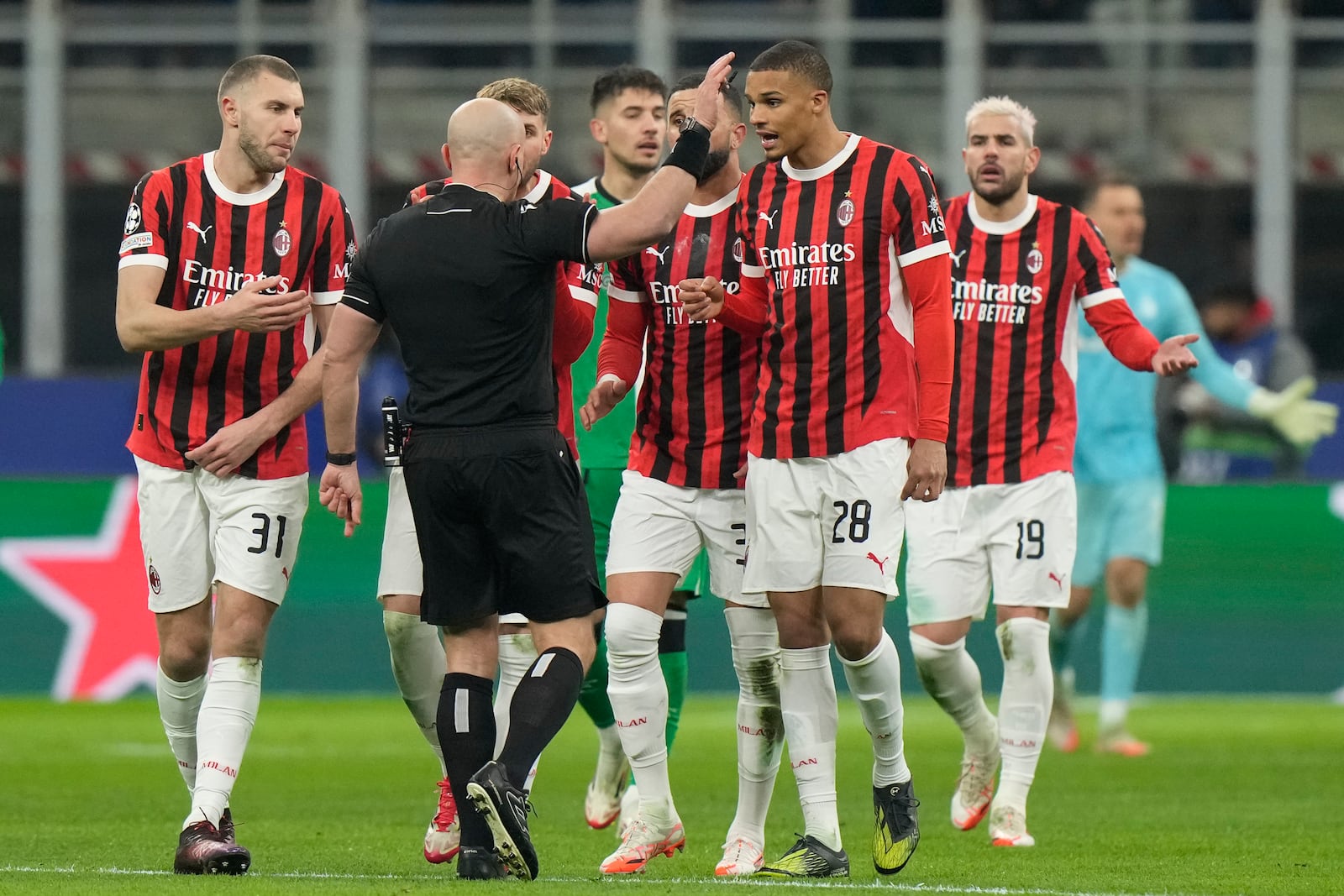 AC Milan's players argue with Referee Szymon Marciniak of Poland after he sent off AC Milan's Theo Hernandez, right, during Champions League, playoff second leg soccer match between AC Milan and Feyenoord, at the San Siro stadium in Milan, Italy, Tuesday, Feb.18, 2025. (AP Photo/Luca Bruno)