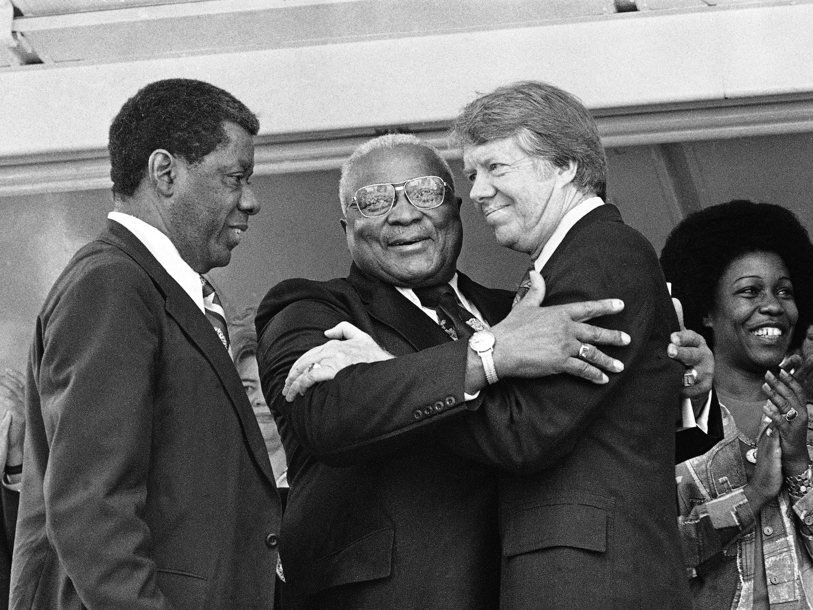 FILE - The Rev. Dr. Martin Luther King Sr., center, and Democratic presidential candidate Jimmy Carter, right, embrace during a campaign rally where King declared, "I love and believe in him," in Atlanta, April 13, 1976. In a prepared speech read by Atlanta businessman Jesse Hill, left, King said Carter has been for equal justice when it wasn't an easy thing to be for in South Georgia. (AP Photo, File)