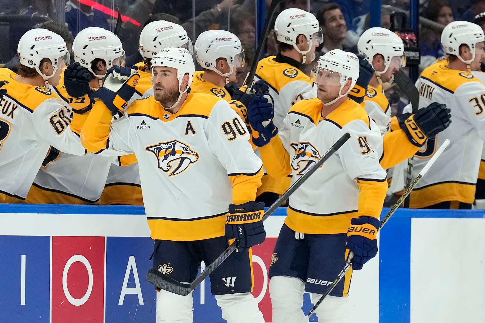 Nashville Predators center Ryan O'Reilly (90) and center Steven Stamkos (91) celebrate with the bench after O'Reilly's goal against the Tampa Bay Lightning during the second period of an NHL hockey game Monday, Oct. 28, 2024, in Tampa, Fla. (AP Photo/Chris O'Meara)