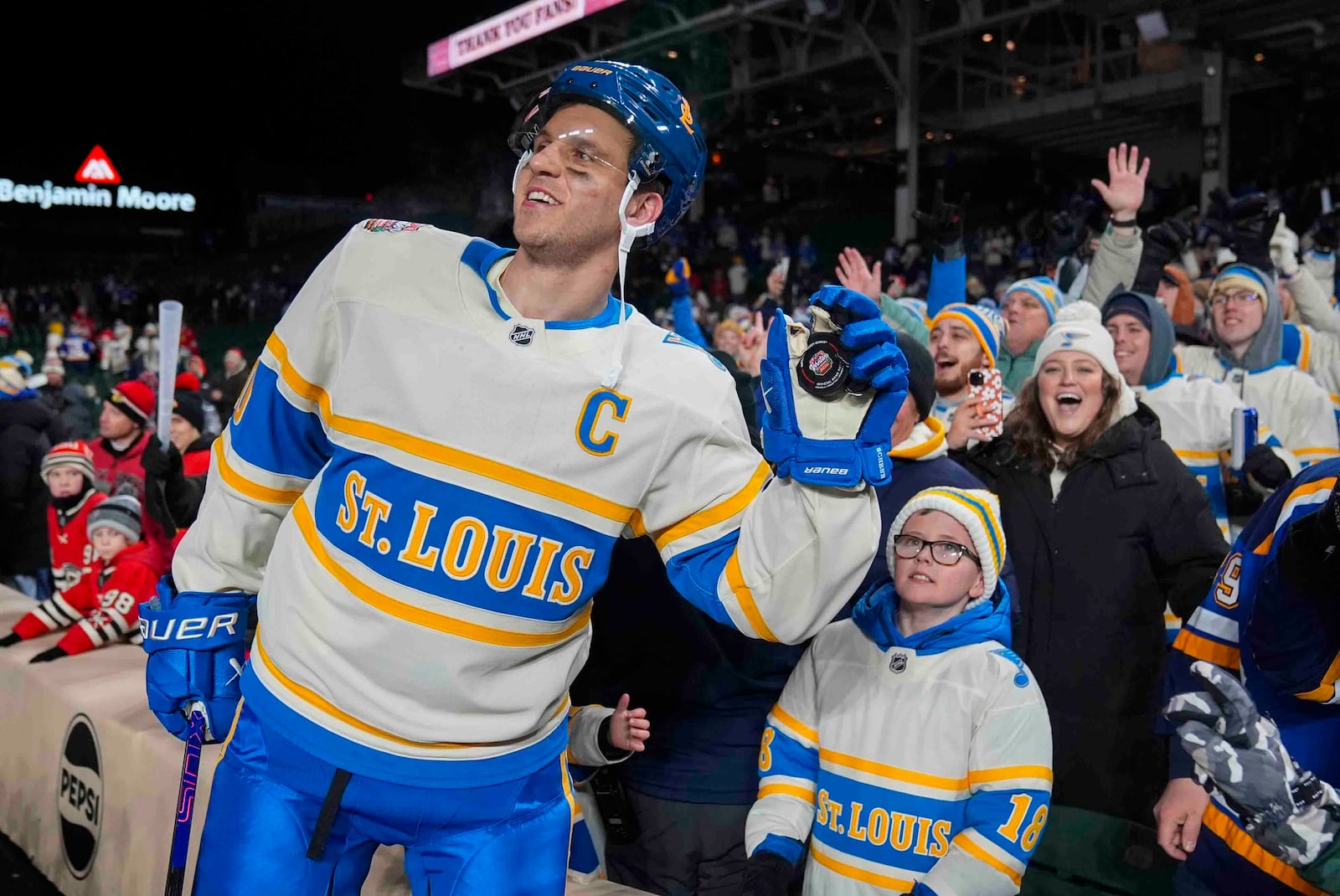 St. Louis Blues center Brayden Schenn, left, celebrates with fans after his team's win over the Chicago Blackhawks in the NHL Winter Classic outdoor hockey game at Wrigley Field, Tuesday, Dec. 31, 2024, in Chicago. (AP Photo/Erin Hooley)