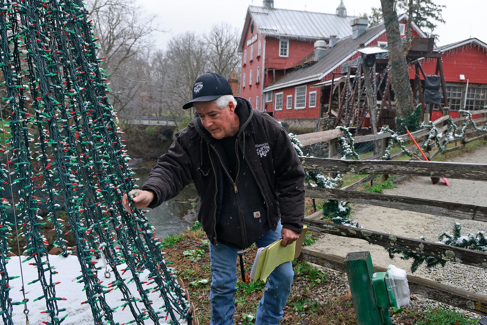 Anthony Satariano, who owns the Historic Clifton Mill with his mom, Pat, checks some of the nearly five million holiday lights before opening night. BILL LACKEY/STAFF