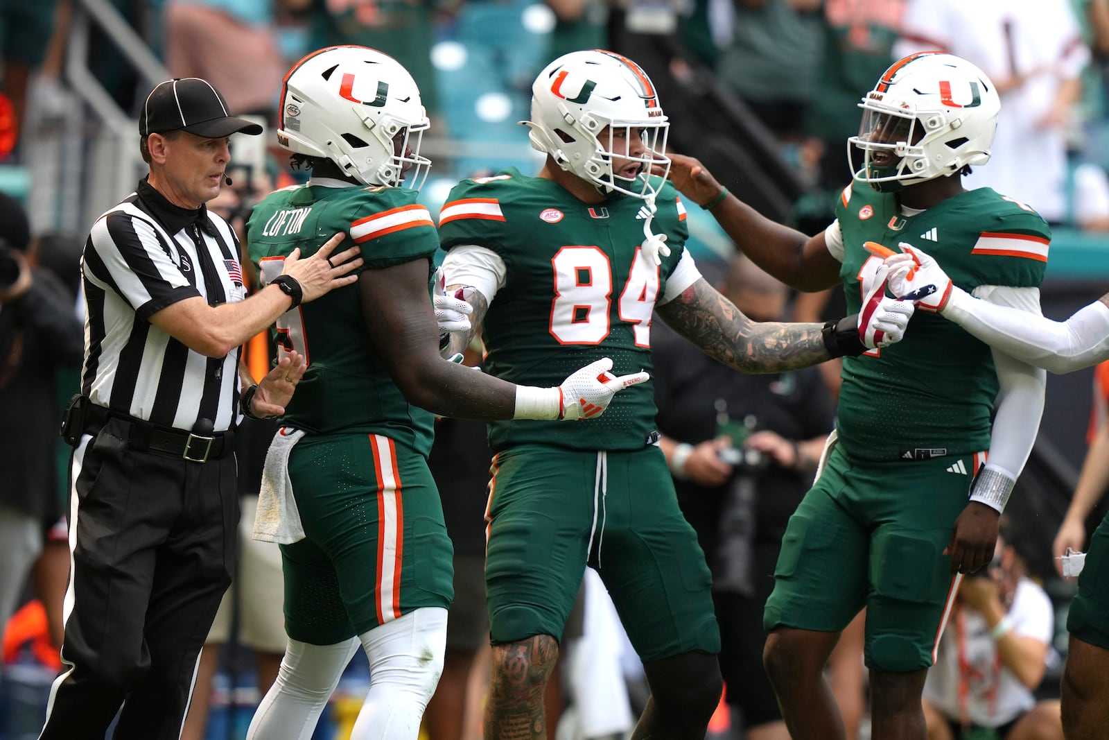 Miami tight end Cam McCormick (84) celebrates with tight end Elija Lofton (9) and quarterback Cam Ward, right, after scoring a touchdown during the first half of an NCAA college football game, Saturday, Nov. 2, 2024, in Miami Gardens, Fla. (AP Photo/Lynne Sladky)