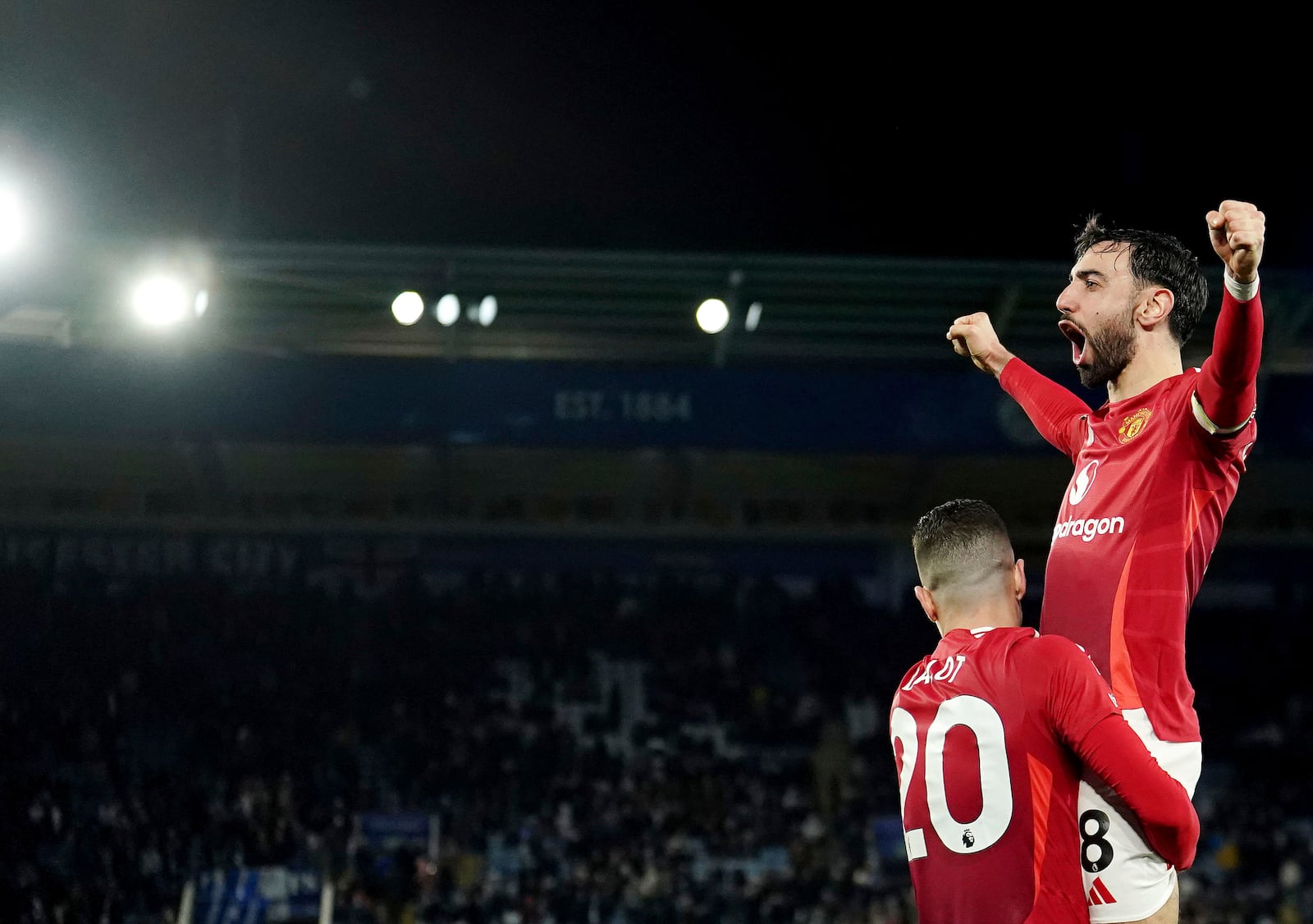 Manchester United's Bruno Fernandes, top right, celebrates scoring his side's third goal during the English Premier League soccer match between Leicester City and Manchester United, at the King Power Stadium, Leicester, England, Sunday March 16, 2025. (Martin Rickett/PA via AP)