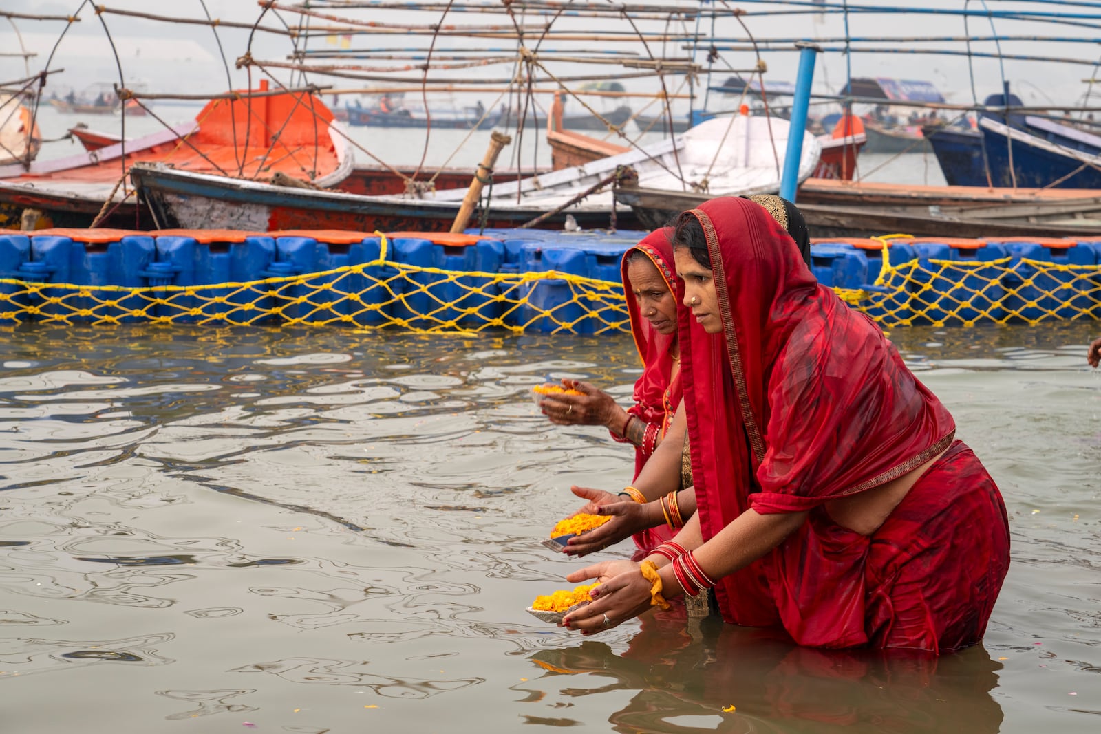 Hindu women devotees pray after taking bath at the confluence of the Ganges, the Yamuna and the mythical Saraswati rivers, a day before the official beginning of the 45-day-long Maha Kumbh festival, in Prayagraj, India, Sunday, Jan. 12, 2025. (AP Photo/Ashwini Bhatia)