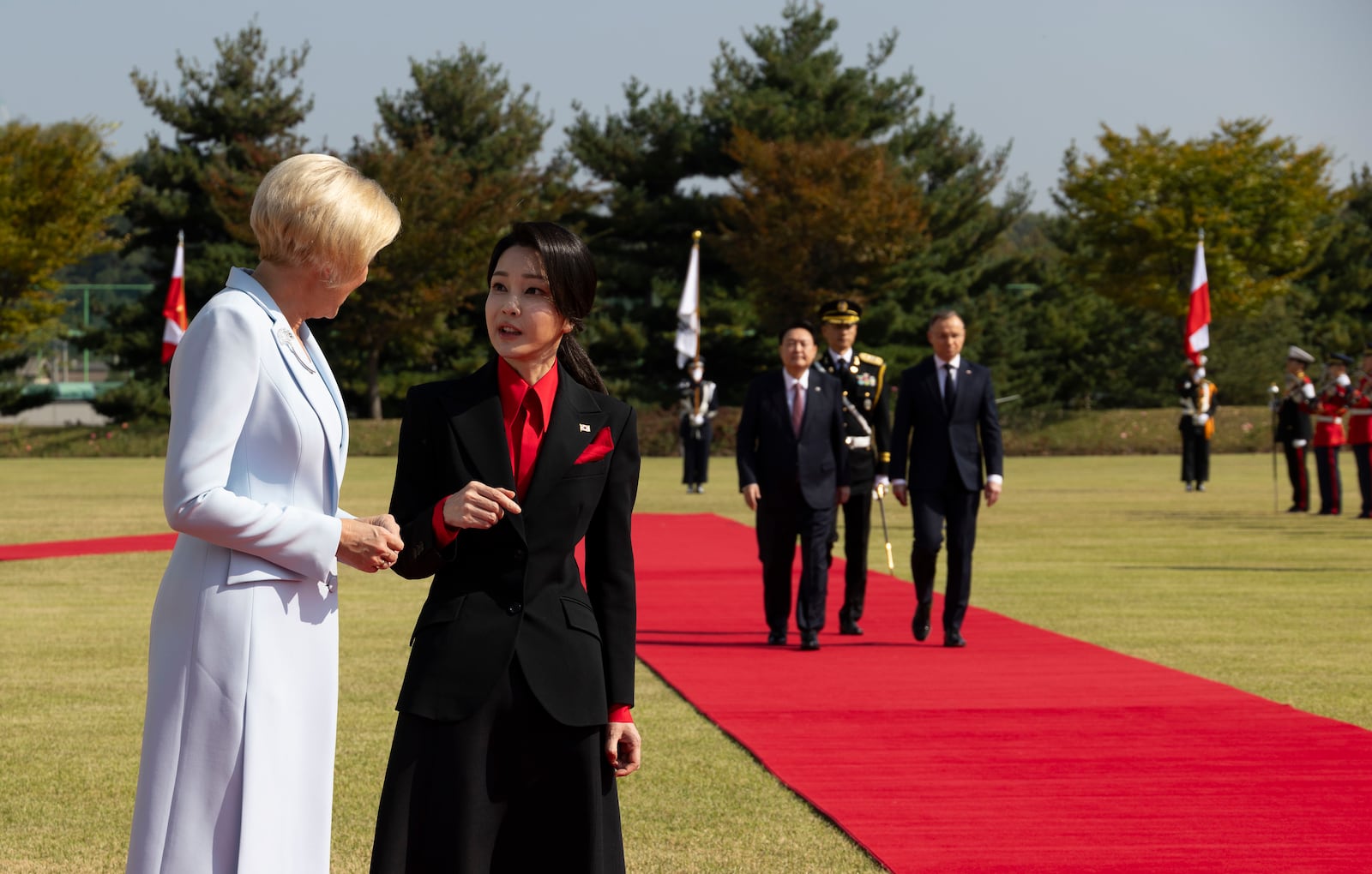 Kim Keon-Hee, second from left, wife of South Korea's president Yoon Suk Yeol, talks with Agata Kornhauser-Duda, left, wife of Poland's president Andrzej Duda, as President Yoon SukYeol, third from left, and President Andrzej Duda, right, walk with honor guards during a welcoming ceremony at the Presidential Office in Seoul, South Korea, Thursday, Oct. 24, 2024. (Jeon Heon-Kyun/Pool Photo via AP)