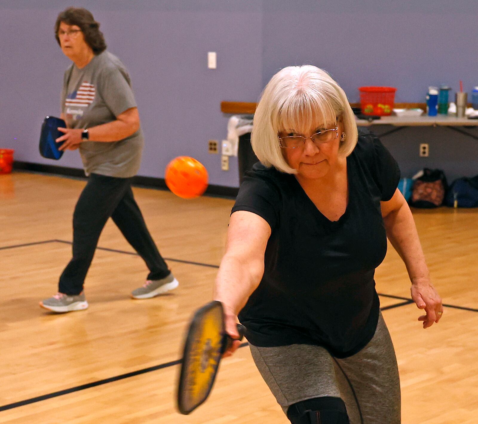 Ica Vega returns the ball as her partner, Helen Webb, stands by during their pickleball match at United Senior Services in Springfield Wednesday, April 19, 2023. BILL LACKEY/STAFF