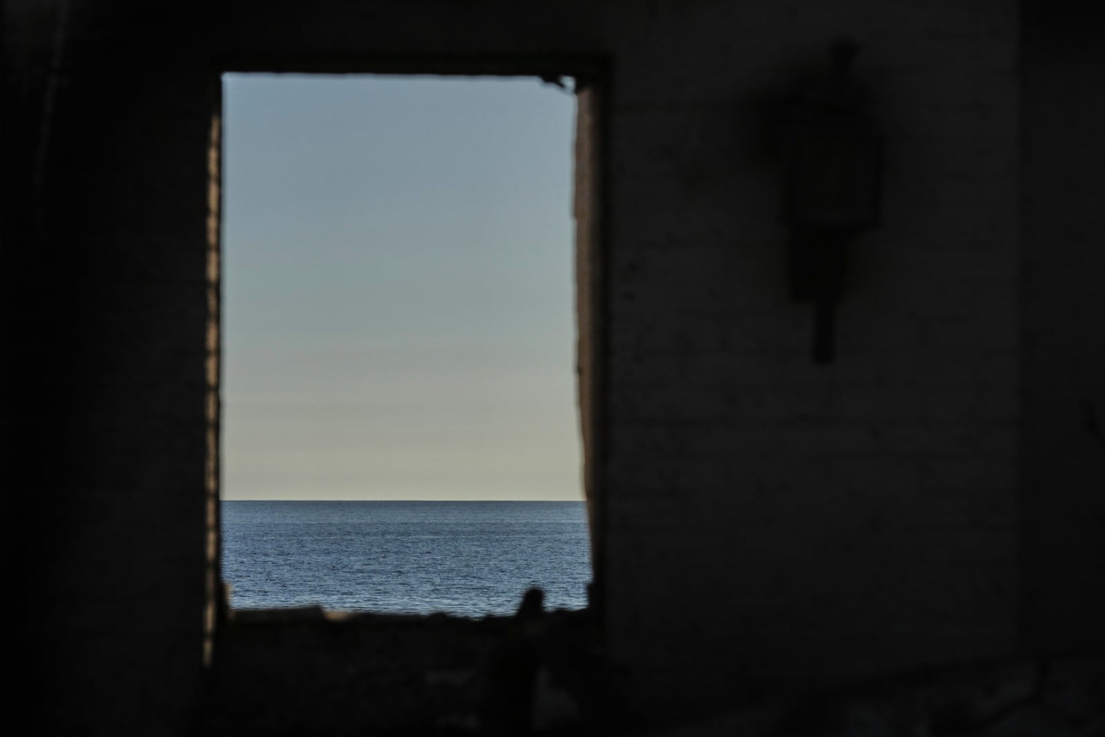 The Pacific Ocean is seen through the window of a home destroyed by the Palisades Fire, Thursday, Jan. 16, 2025, in Malibu, Calif. (AP Photo/Jae C. Hong)