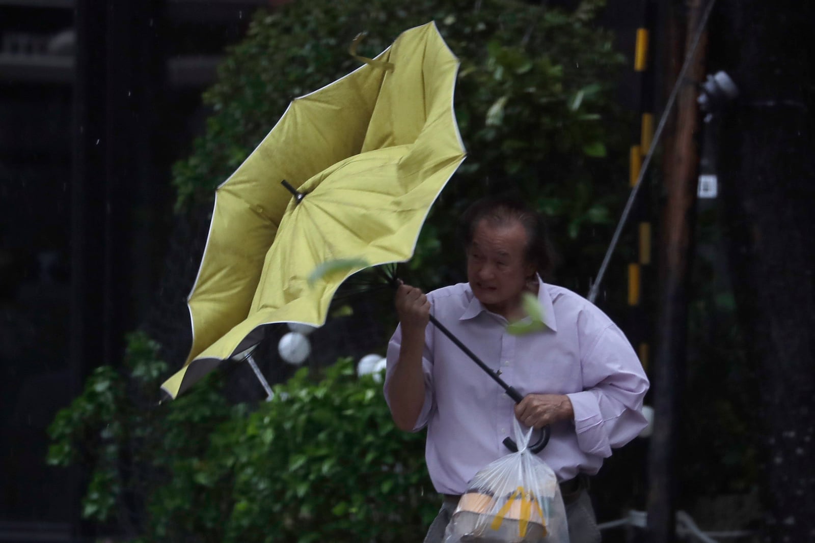 A man struggles with his umbrella against gusts of wind generated by Typhoon Kong-rey in Taipei, Taiwan, Thursday, Oct. 31, 2024. (AP Photo/Chiang Ying-ying)