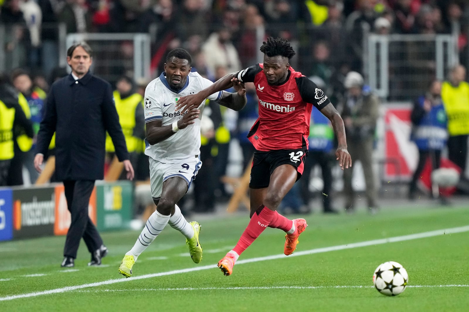 Inter Milan's Marcus Thuram vies for the ball with Leverkusen's Edmond Tapsoba, right, during the Champions League opening phase soccer match between Bayer Leverkusen and Inter Milan at the BayArena in Leverkusen, Germany, Tuesday Dec. 10, 2024. (AP Photo/Martin Meissner)