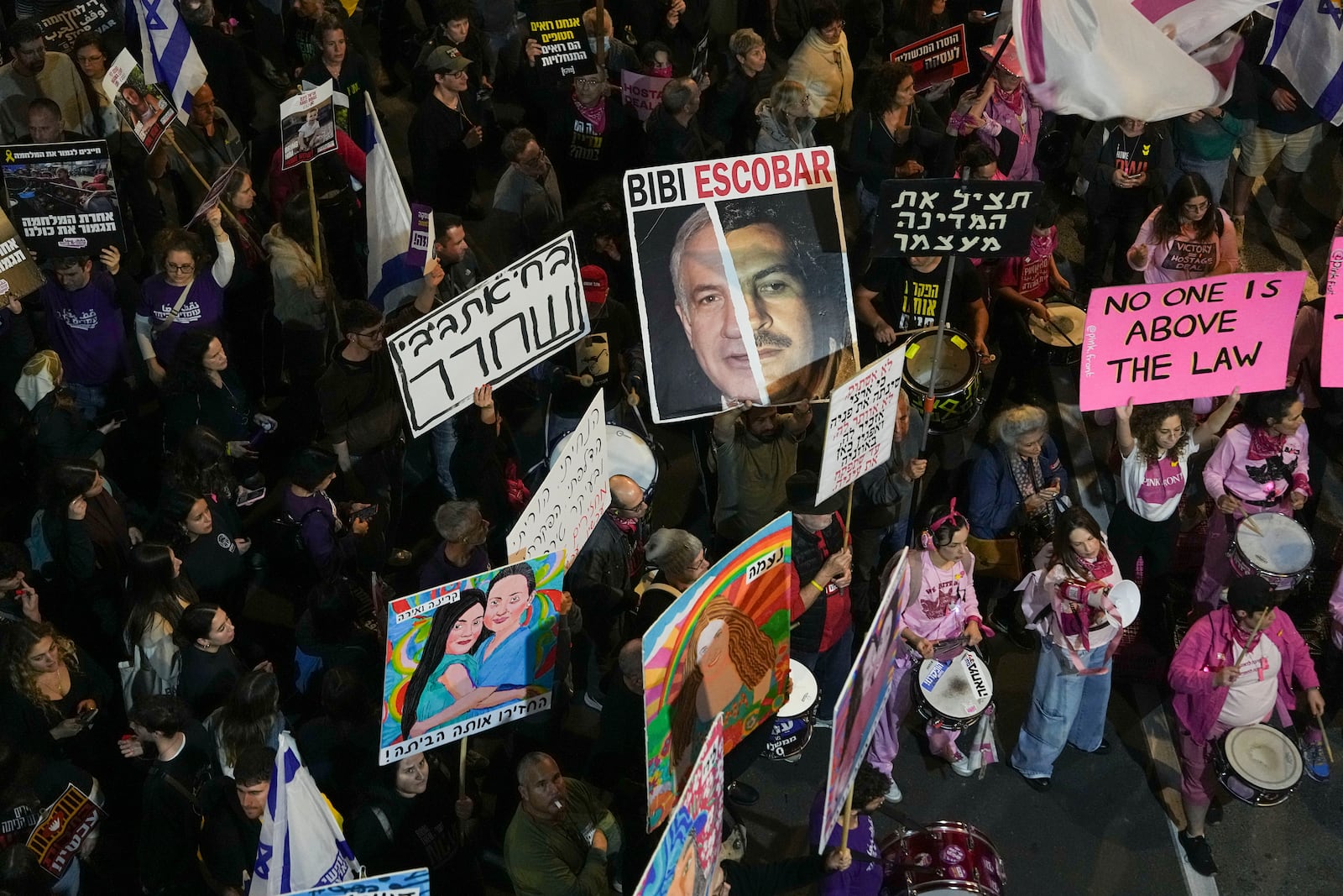 Israelis protest against Prime Minister Benjamin Netanyahu's government and call for the release of hostages held in the Gaza Strip by the Hamas militant group, in Tel Aviv, Israel, Saturday, Dec. 14, 2024. (AP Photo/Tsafrir Abayov)