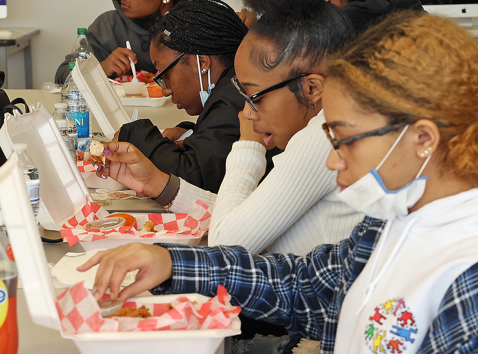 Springfield High School students enjoy the chicken and waffle meals that Kareem Crossley, the owner of Bubby's Chicken & Waffles, brought for them as he talks about the rewards and struggles of starting your own business Thursday as they enjoy the chicken and waffle meals he brought for them. BILL LACKEY/STAFF